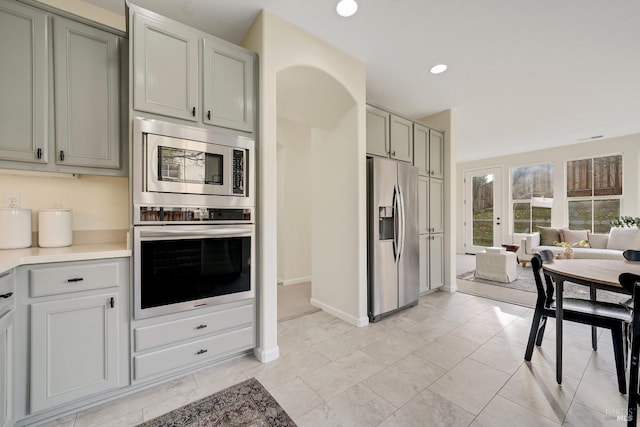 kitchen featuring baseboards, stainless steel appliances, light countertops, and recessed lighting