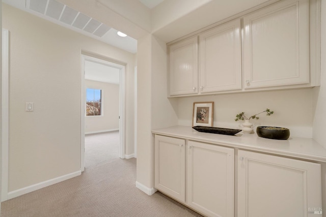 hallway with light carpet and baseboards