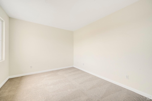 carpeted empty room with baseboards and a wealth of natural light