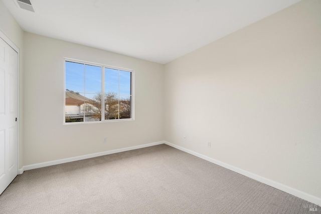 unfurnished room with carpet flooring, visible vents, and baseboards