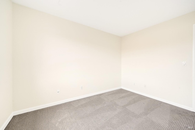 unfurnished room with carpet and baseboards