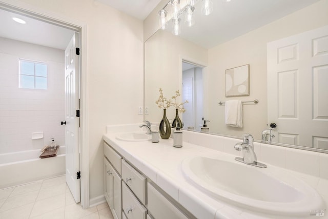 full bathroom with double vanity, tile patterned flooring, and a sink