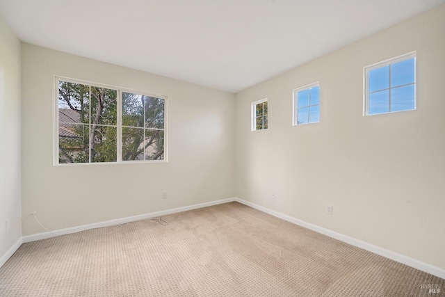 carpeted spare room featuring baseboards