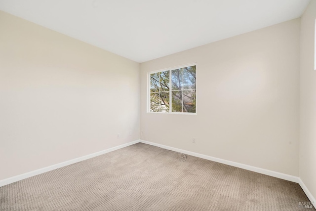 empty room featuring carpet flooring and baseboards