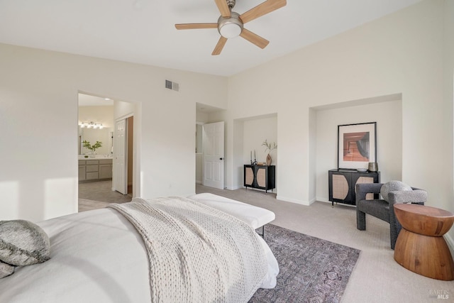 bedroom with visible vents, ensuite bathroom, light carpet, vaulted ceiling, and baseboards