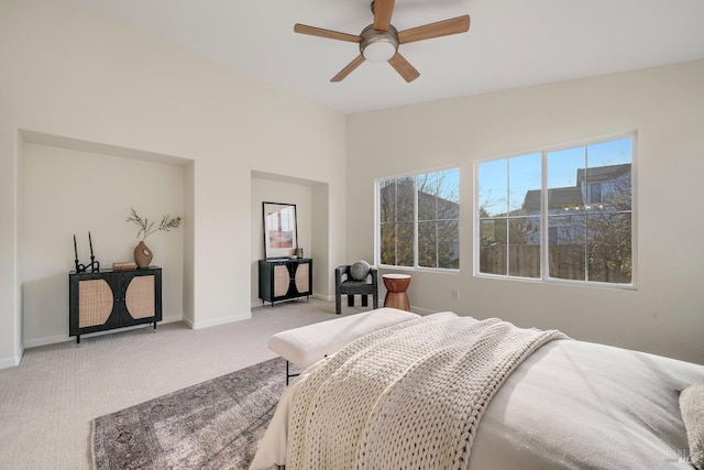 bedroom with light carpet, baseboards, vaulted ceiling, and a ceiling fan