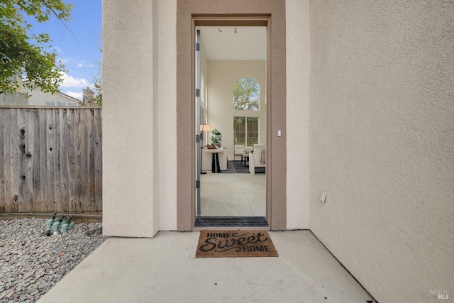 property entrance featuring fence and stucco siding