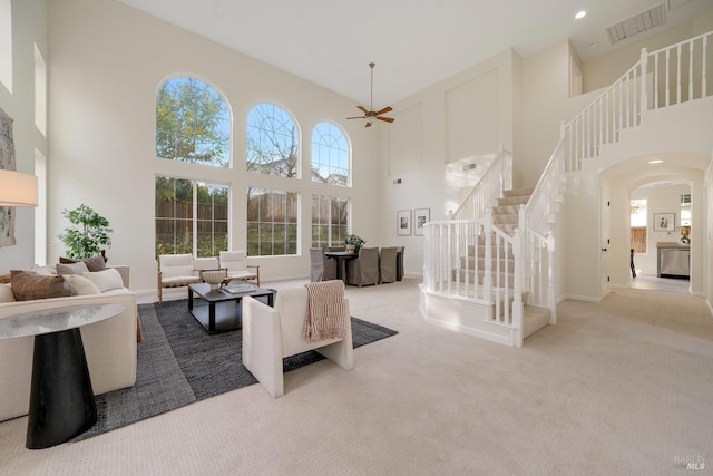 living area with light carpet, stairway, plenty of natural light, and visible vents