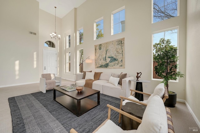 living room featuring carpet floors, baseboards, visible vents, and a notable chandelier