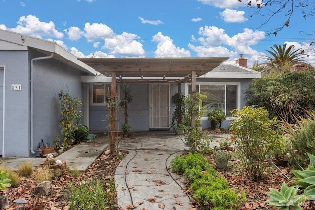 doorway to property featuring a pergola