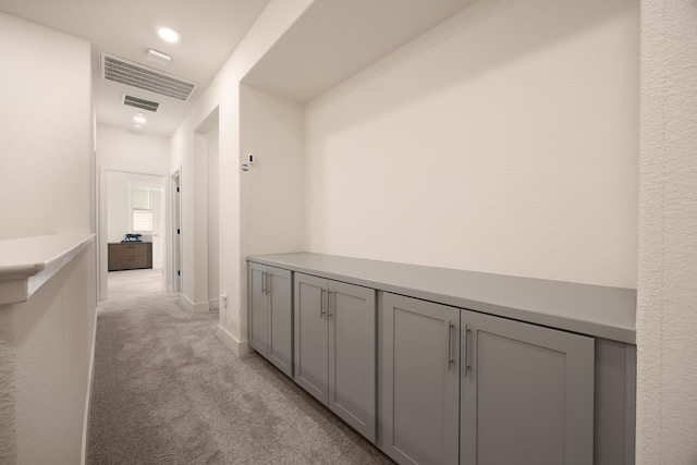 hall with recessed lighting, baseboards, visible vents, and light colored carpet