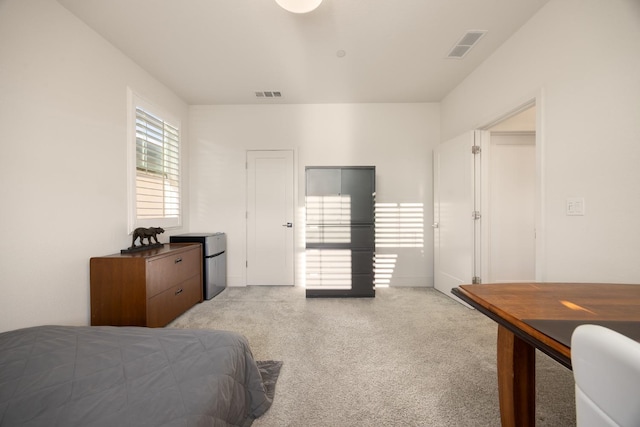 bedroom featuring visible vents and light colored carpet