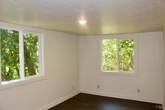 unfurnished room featuring a textured ceiling and dark hardwood / wood-style floors