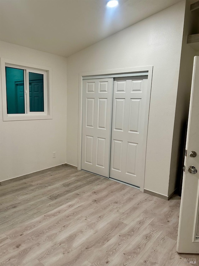 unfurnished bedroom featuring a closet and light hardwood / wood-style floors