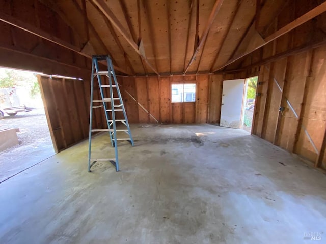 miscellaneous room with concrete flooring and lofted ceiling