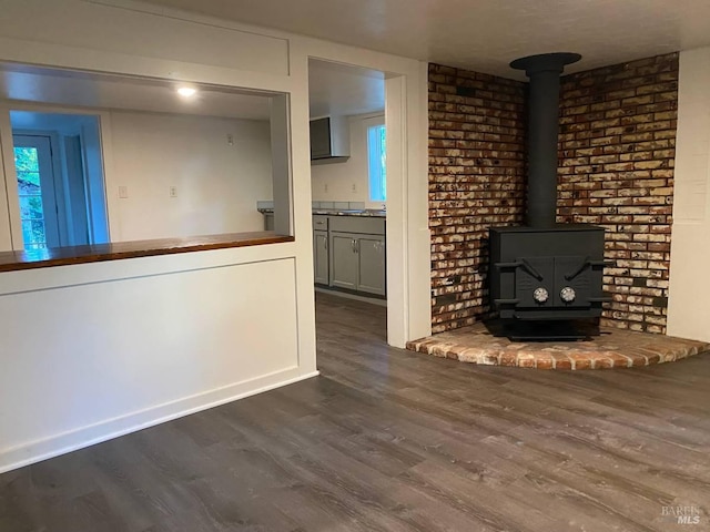 unfurnished living room featuring dark hardwood / wood-style flooring and a wood stove