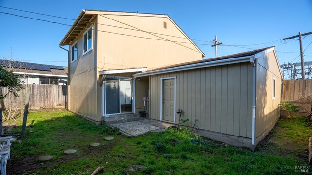 rear view of house featuring a yard