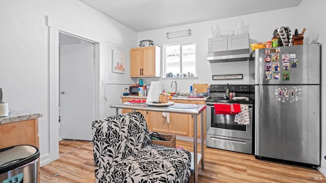 kitchen featuring appliances with stainless steel finishes, light brown cabinets, light hardwood / wood-style flooring, and sink