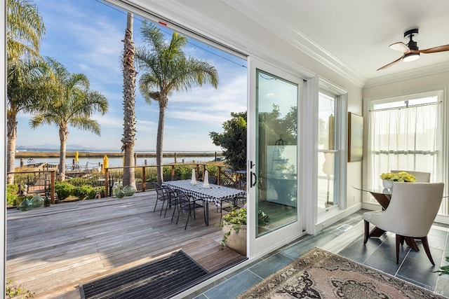 sunroom / solarium with ceiling fan and a water view