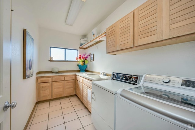 laundry area featuring cabinets, light tile patterned floors, washing machine and dryer, and sink