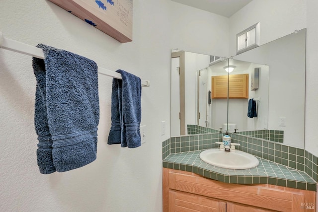 bathroom featuring vanity and backsplash