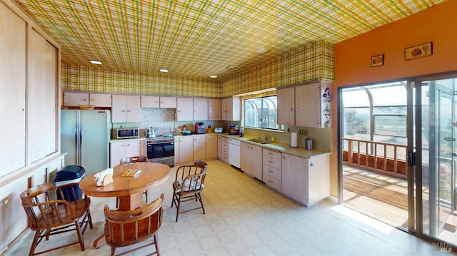 kitchen with appliances with stainless steel finishes, sink, and decorative backsplash