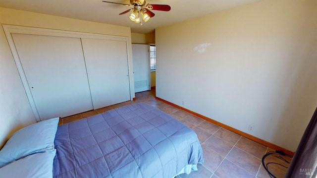 bedroom featuring light tile patterned flooring, ceiling fan, and a closet