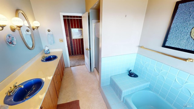 bathroom with vanity and tiled tub