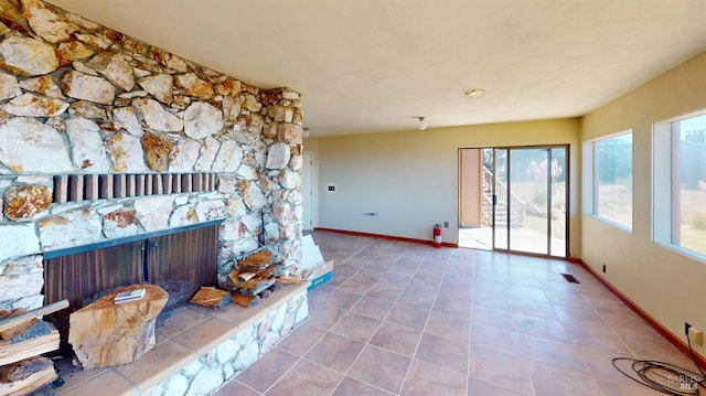 interior space featuring tile patterned flooring and a stone fireplace