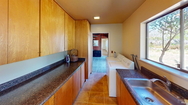 kitchen featuring separate washer and dryer, sink, and light tile patterned floors