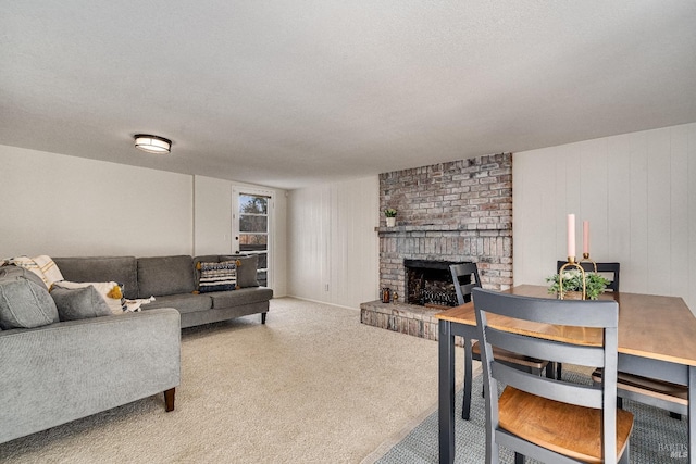 carpeted living room featuring a textured ceiling and a fireplace