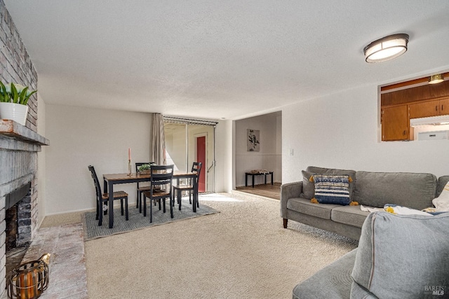 carpeted living room with a fireplace and a textured ceiling