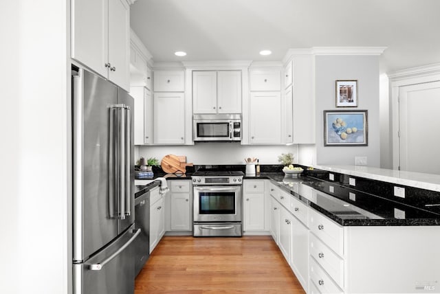 kitchen featuring white cabinetry, dark stone counters, kitchen peninsula, stainless steel appliances, and light hardwood / wood-style flooring