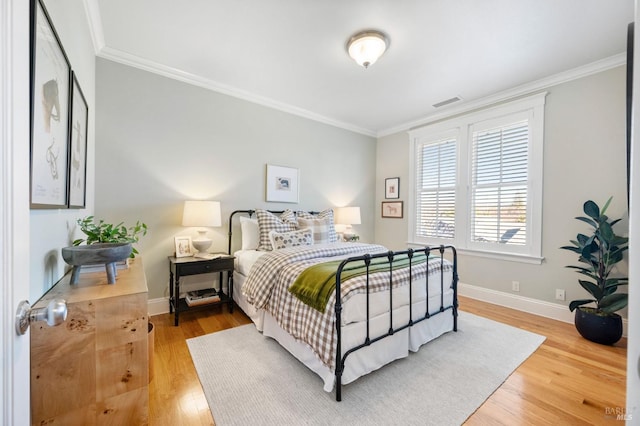 bedroom with crown molding and hardwood / wood-style floors