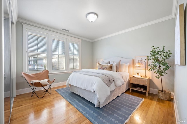 bedroom with hardwood / wood-style flooring and crown molding