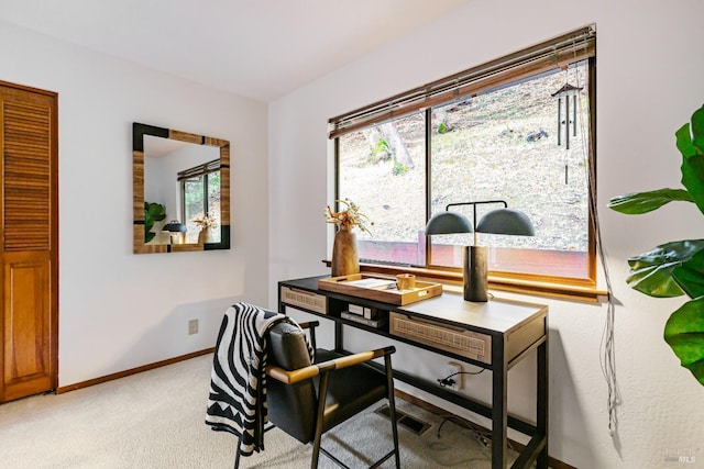 office area with baseboards, visible vents, and light carpet