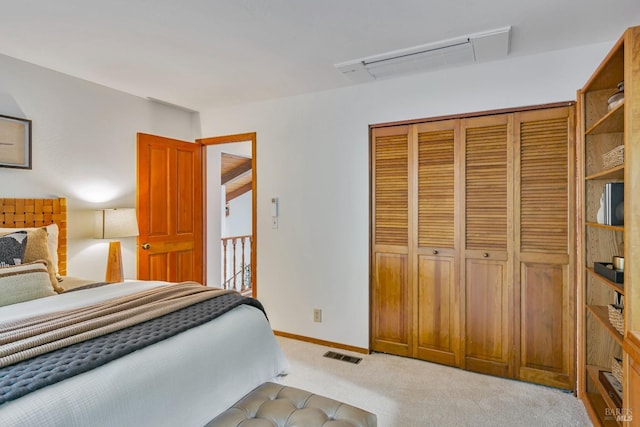 bedroom with a closet, visible vents, carpet flooring, and baseboards