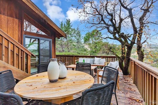 wooden terrace with outdoor dining space and an outdoor hangout area