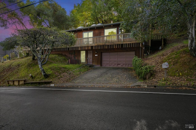 view of front property with a wooden deck, central AC unit, and a garage