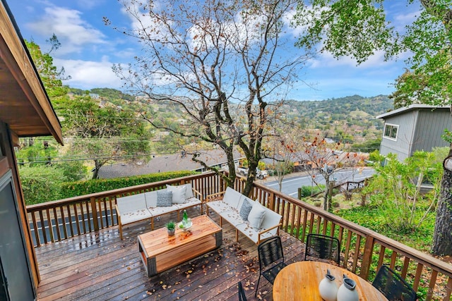 deck featuring outdoor lounge area and a mountain view