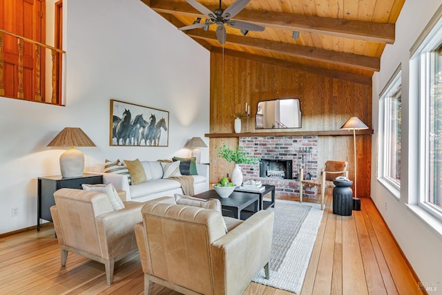 living room featuring light wood-type flooring, a brick fireplace, wood ceiling, ceiling fan, and lofted ceiling with beams