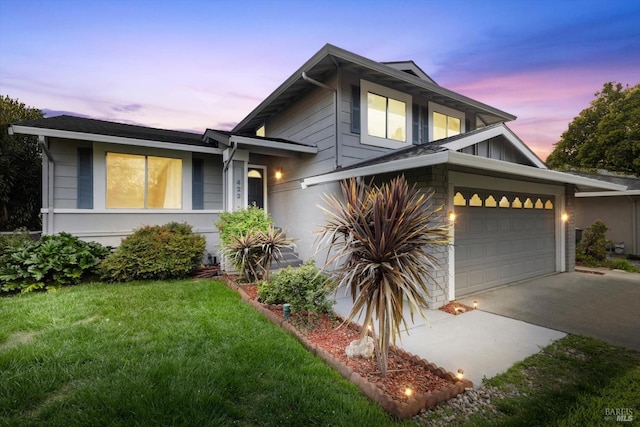 tri-level home with a garage, stone siding, a yard, and driveway