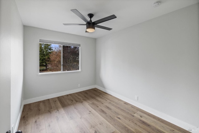 unfurnished room featuring wood finished floors, baseboards, and ceiling fan