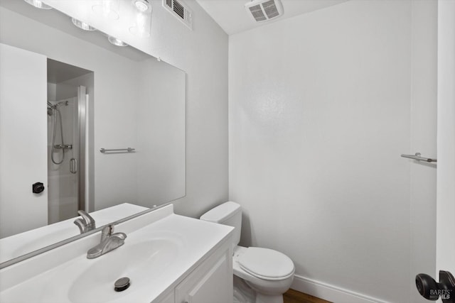 bathroom featuring visible vents, toilet, a stall shower, and vanity