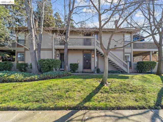 view of front of house featuring stairway and a front lawn