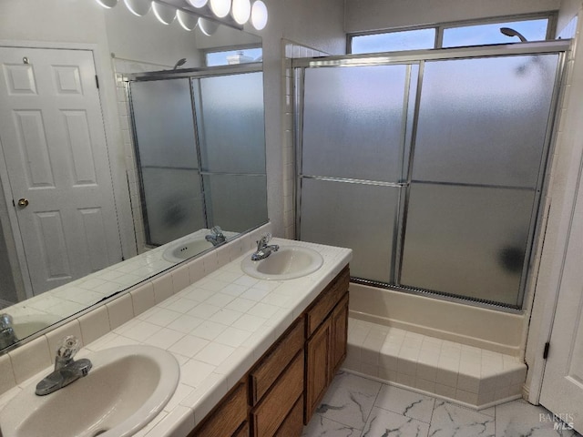 bathroom with vanity and shower / bath combination with glass door