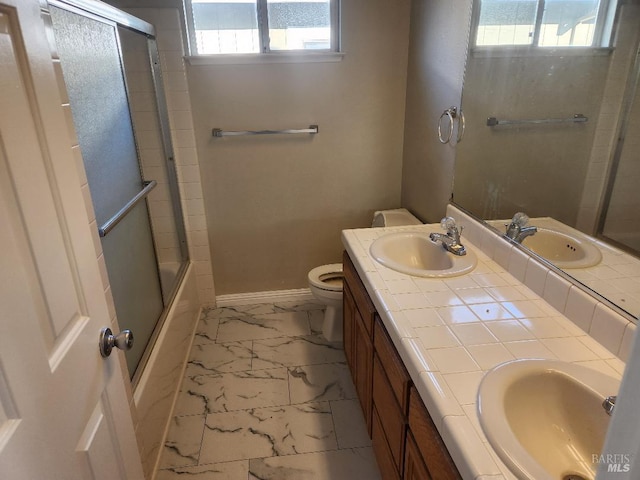 full bathroom with vanity, toilet, and bath / shower combo with glass door