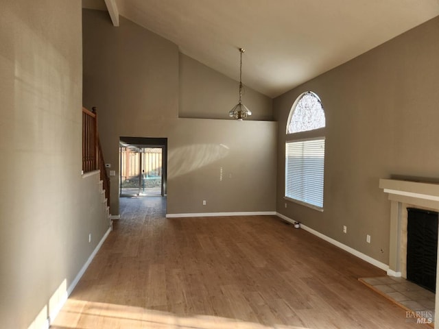 unfurnished living room with a fireplace, hardwood / wood-style flooring, high vaulted ceiling, and beamed ceiling