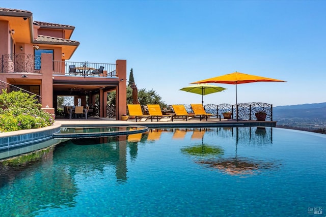 view of pool with a mountain view and a pool with connected hot tub