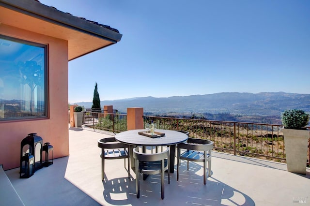 view of patio with a mountain view and a balcony